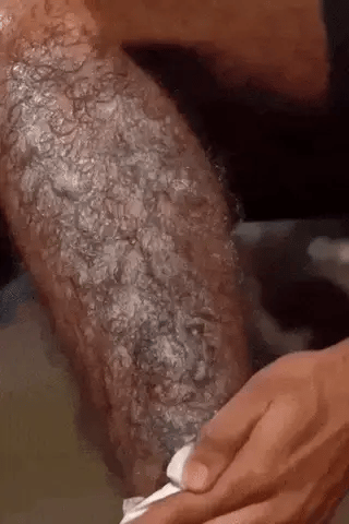 Hair spray foam on skin as a hand smooths and wipes on an underarm area.