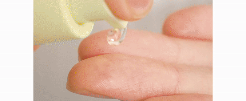 Clear skincare serum droplet on fingertip