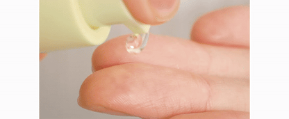 Clear skincare serum droplet on fingertip