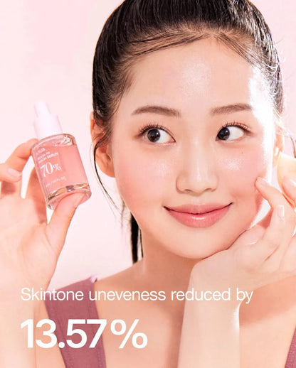 Anua Niacin Serum bottle beside face, woman applying skincare with dropper