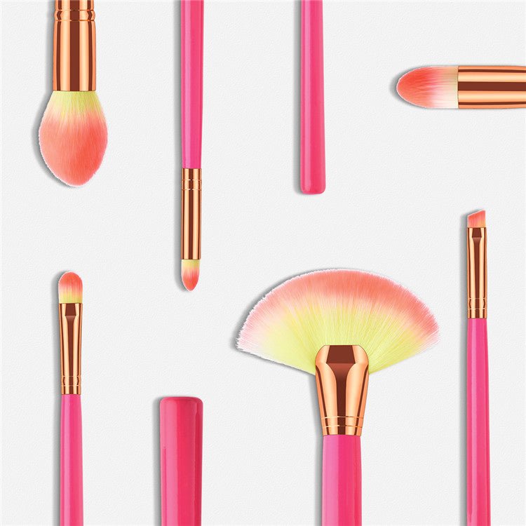 Makeup brush set close-up: pink handles, gold ferrules, soft fan and round brush heads