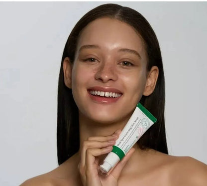 AXIS-Y dark spot correcting glow serum tube held near face, green cap