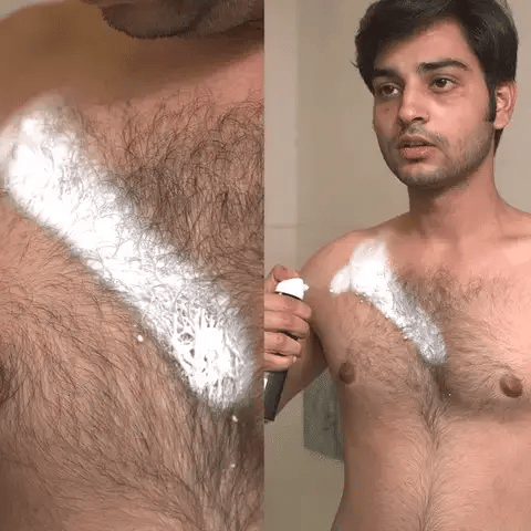 Man applying hair spray foam to chest with a bottle held near the skin.