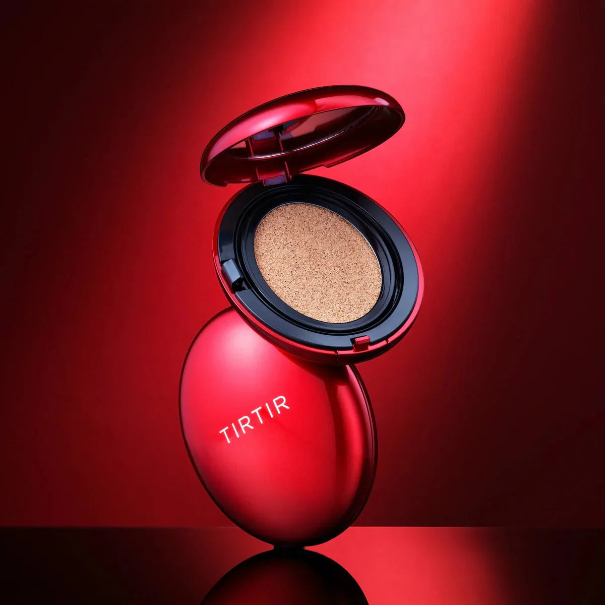 Red cushion compact with lid open, showing beige cushion center; TIRTIR logo
