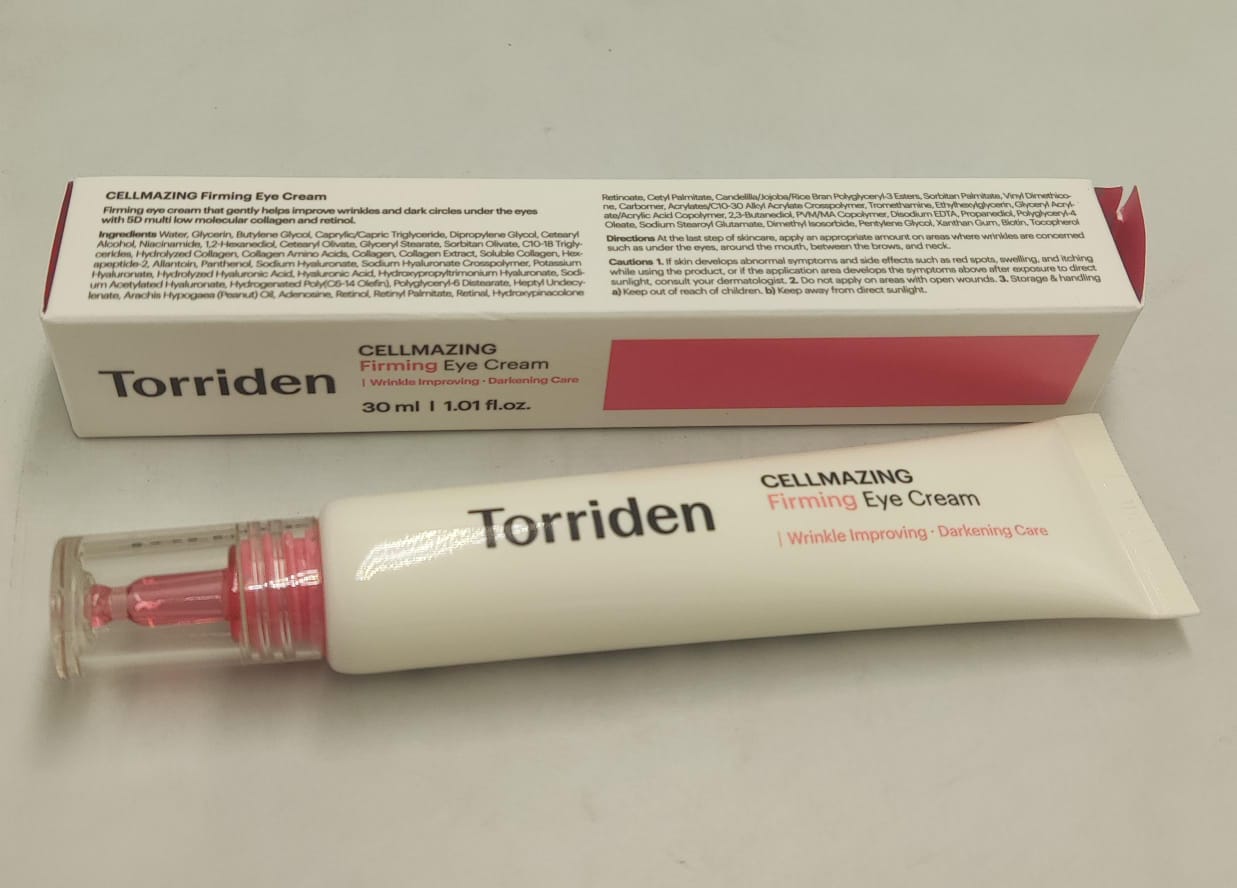Torriden eye cream box and cream tube with pink cap, lying on a flat surface