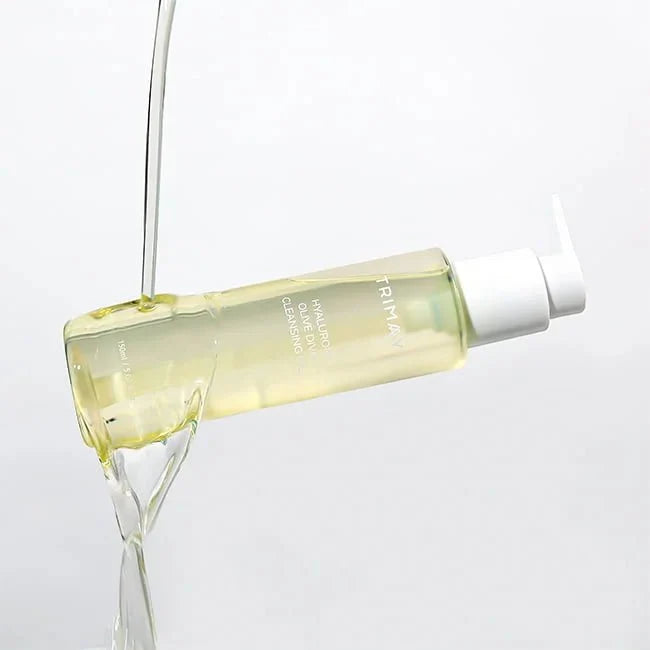 Gold cleansing oil in clear bottle with white pump, pouring