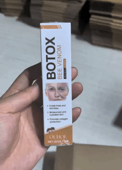 Bee venom wrinkle cream tube held in hand, white and gold label with nozzle tip
